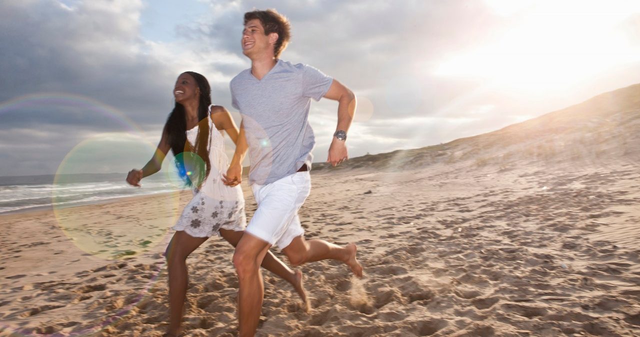 07 Feb 2014 --- Young couple running on beach --- Image by © Zero Creatives/Corbis