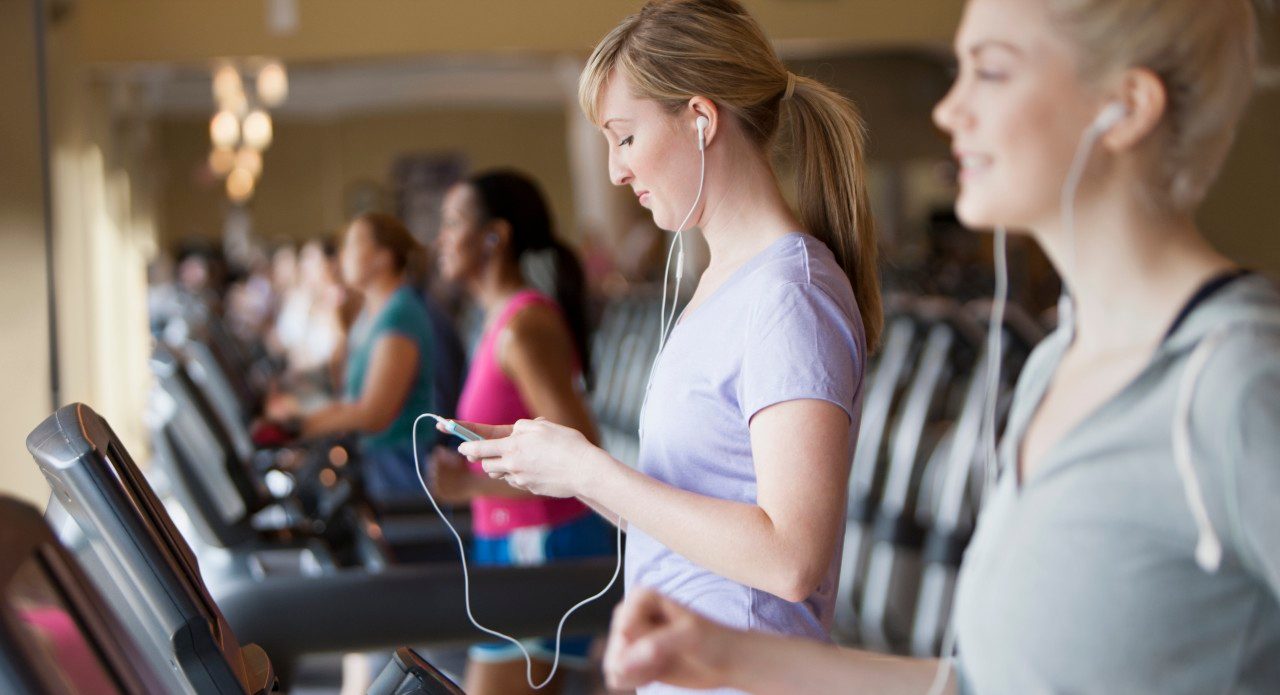 11 May 2012 --- Caucasian women using mp3 players on treadmills in gym --- Image by © Jose Luis Pelaez Inc/Blend Images/Corbis