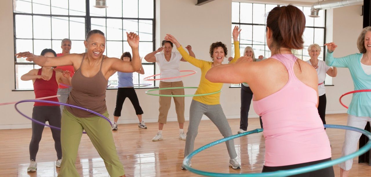 10 Apr 2011 --- Women spinning plastic hoops in fitness class --- Image by © Ariel Skelley/Blend Images/Corbis