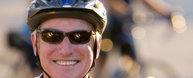 Caucasian man on bicycle giving thumbs up