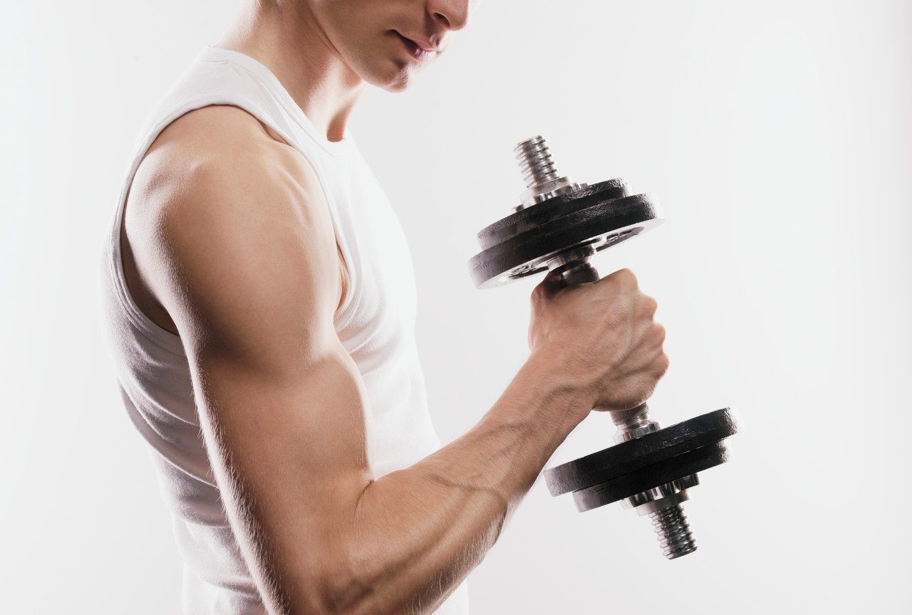 Man holding dumbbell --- Image by © Bernd Vogel/Corbis