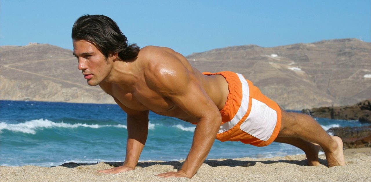 Young sporty man working out on beach --- Image by © Michael Reh/Corbis