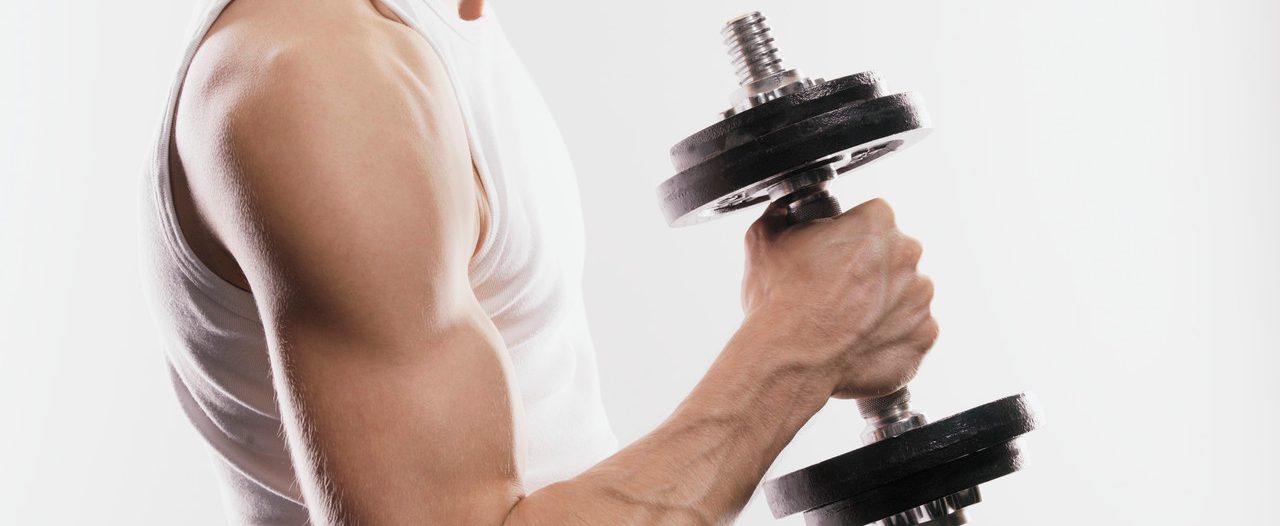 Man holding dumbbell --- Image by © Bernd Vogel/Corbis