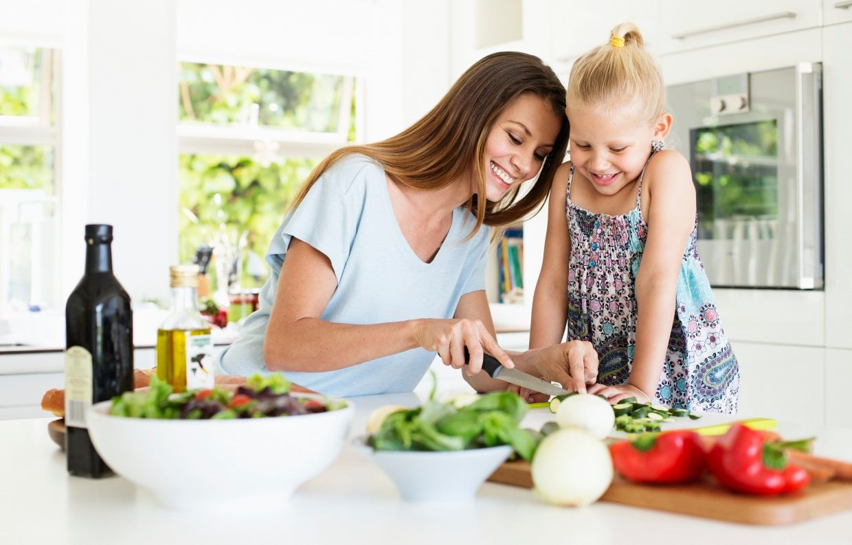 Mother and daughter (4-5) preparing food in kitchen --- Image by © Tomas Rodriguez/Corbis