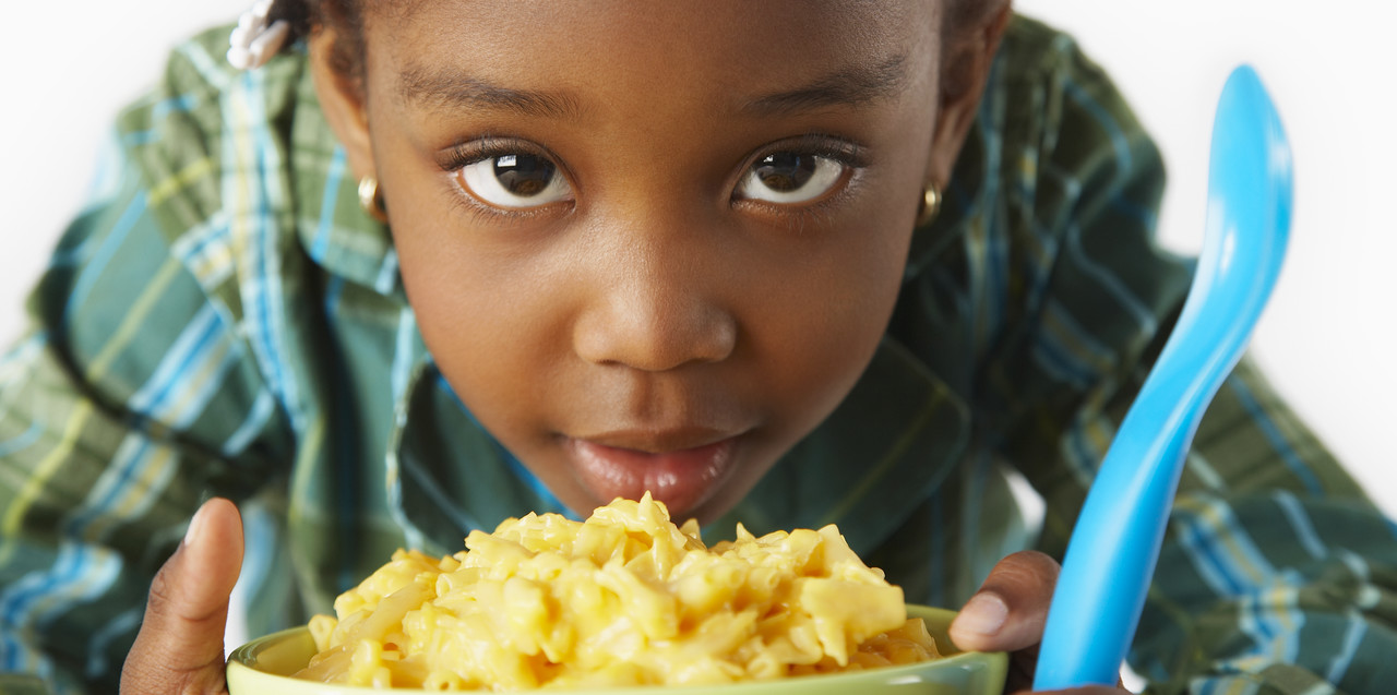 Girl Eating Macaroni and Cheese --- Image by © Sean Justice/Corbis