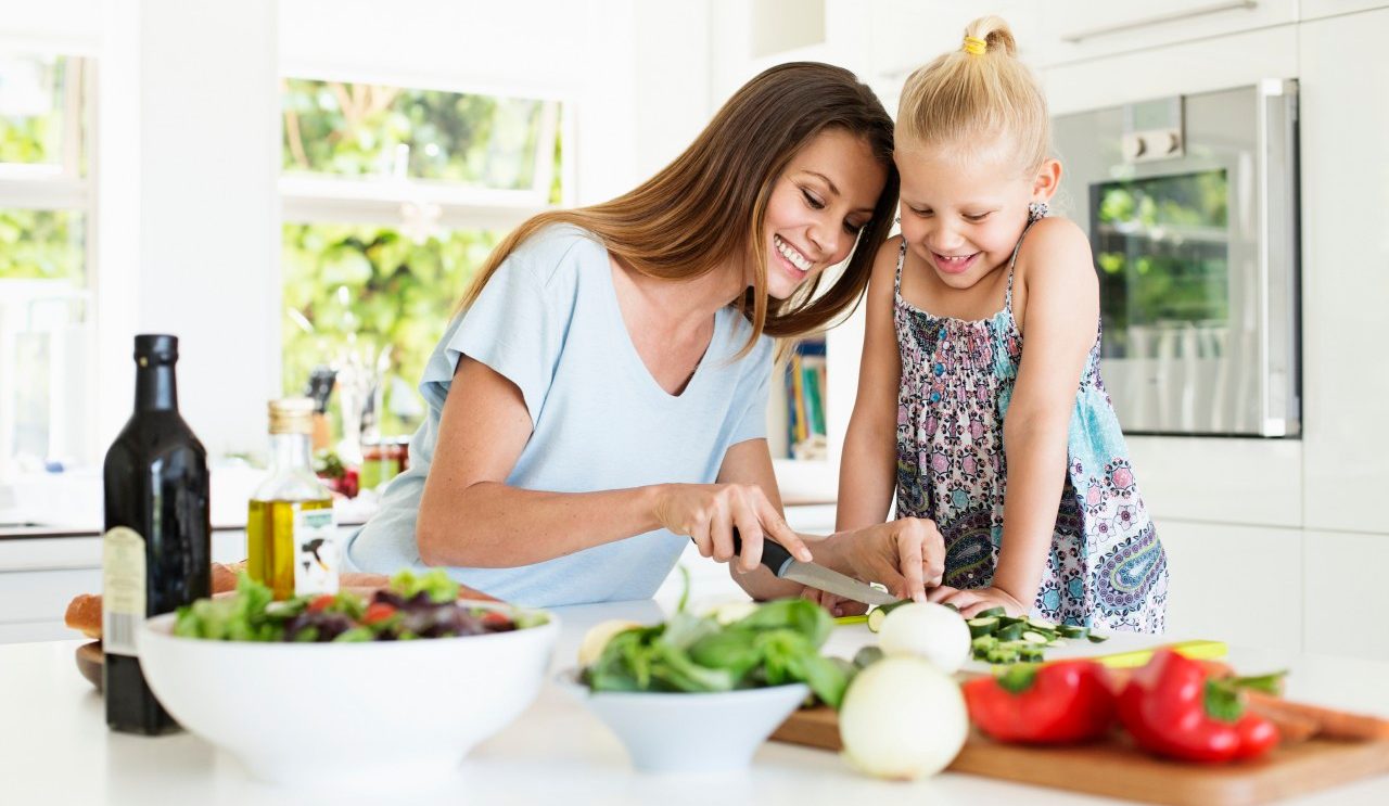 Mother and daughter (4-5) preparing food in kitchen --- Image by © Tomas Rodriguez/Corbis