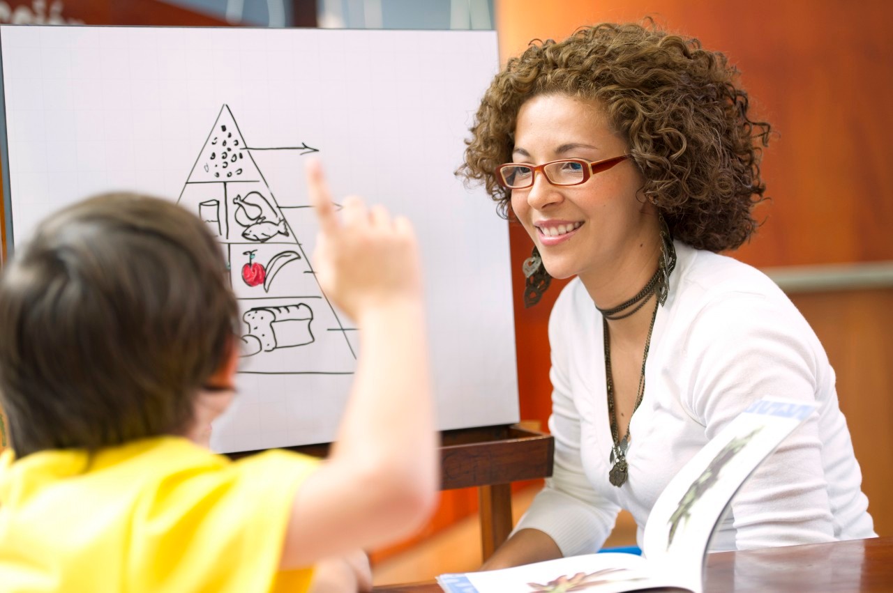 Medellin, Colombia --- Hispanic teacher helping student --- Image by © GM Visuals /Blend Images/Corbis