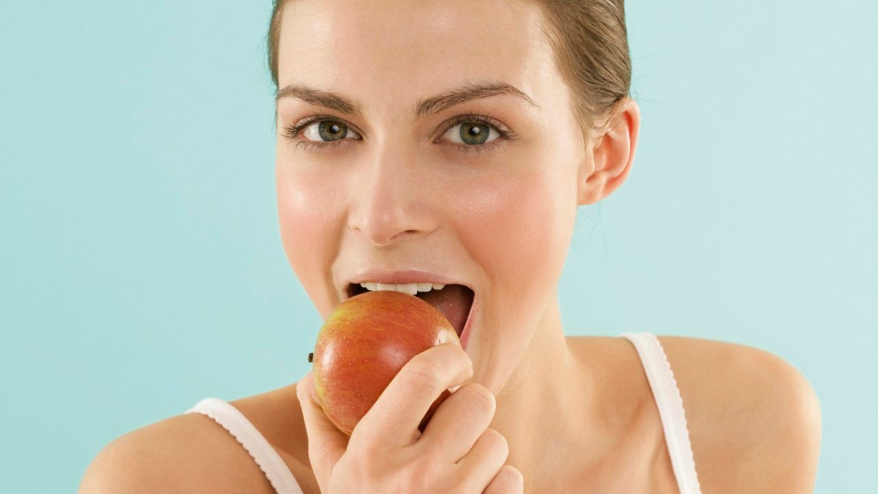 Woman eating an apple --- Image by © RG Images/Stock4B/Corbis