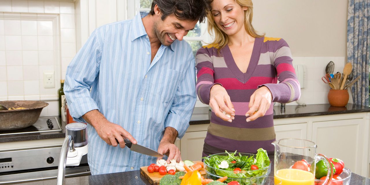 Man and woman making salad --- Image by © Juice Images/Corbis