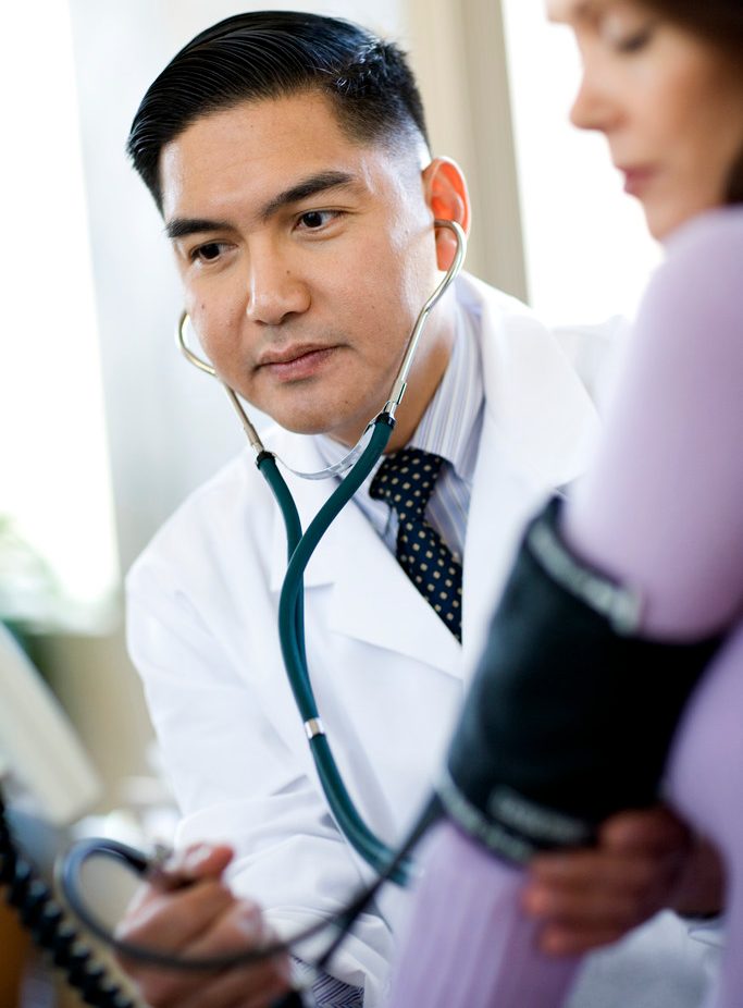 Doctor Taking Woman's Pulse --- Image by © Timothy Tadder/Corbis