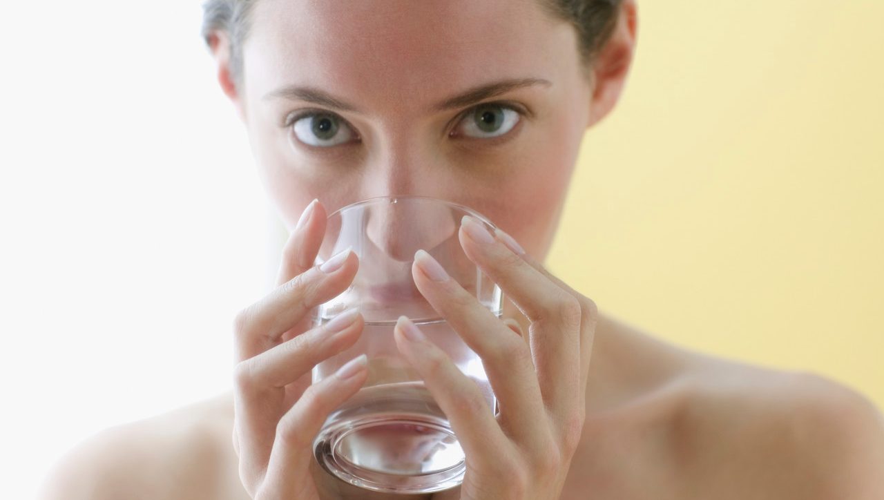 Young woman drinking a glass of water --- Image by © Jose Luis Pelaez, Inc./Blend Images/Corbis