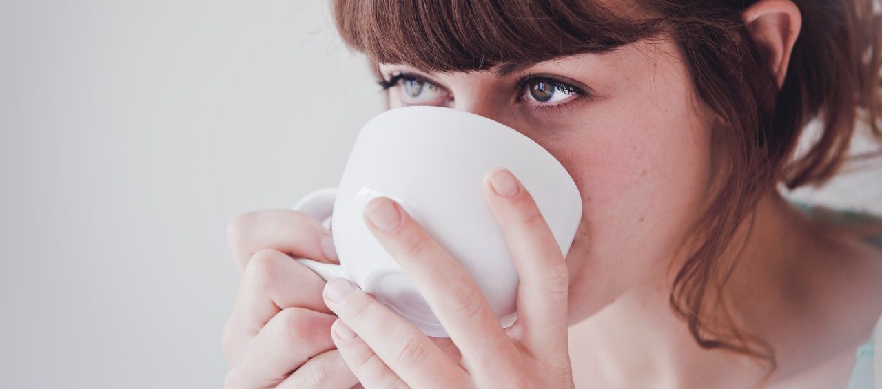 Young woman drinking tea --- Image by © Hannah Mentz/Corbis