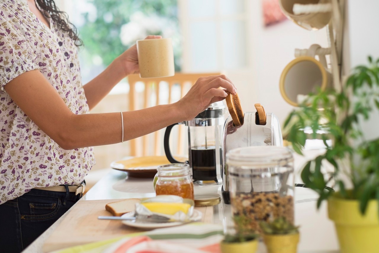 18 Sep 2014 --- Mixed race woman preparing breakfast in kitchen --- Image by © JGI/Tom Grill/Blend Images/Corbis