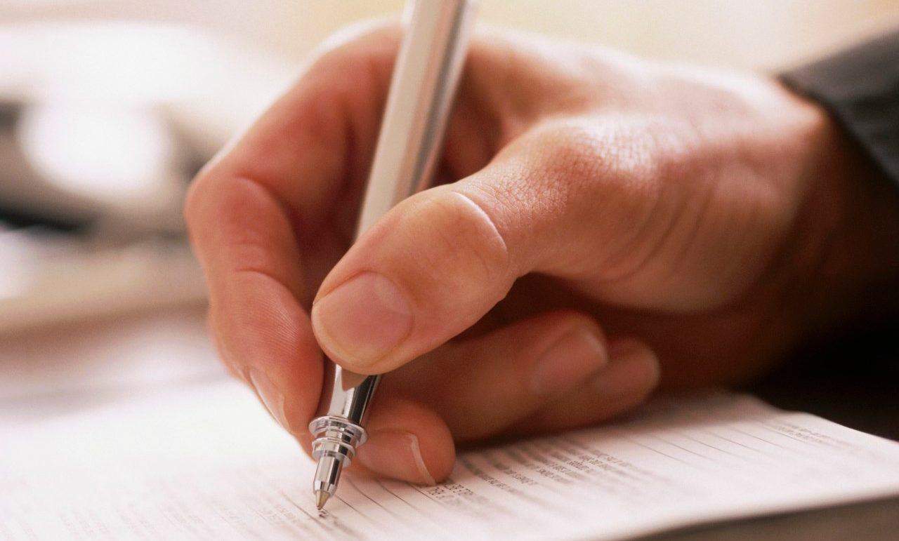 Man writing with a pen --- Image by © Rob Lewine/Tetra Images/Corbis