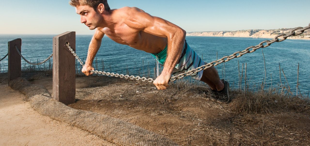 24 Sep 2014, San Diego, California, USA --- Mid adult man doing push up on chain rope --- Image by © Corey Jenkins/Corbis