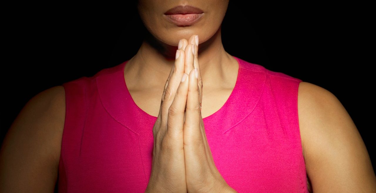 Woman with hands together --- Image by © Mark Weiss/Corbis