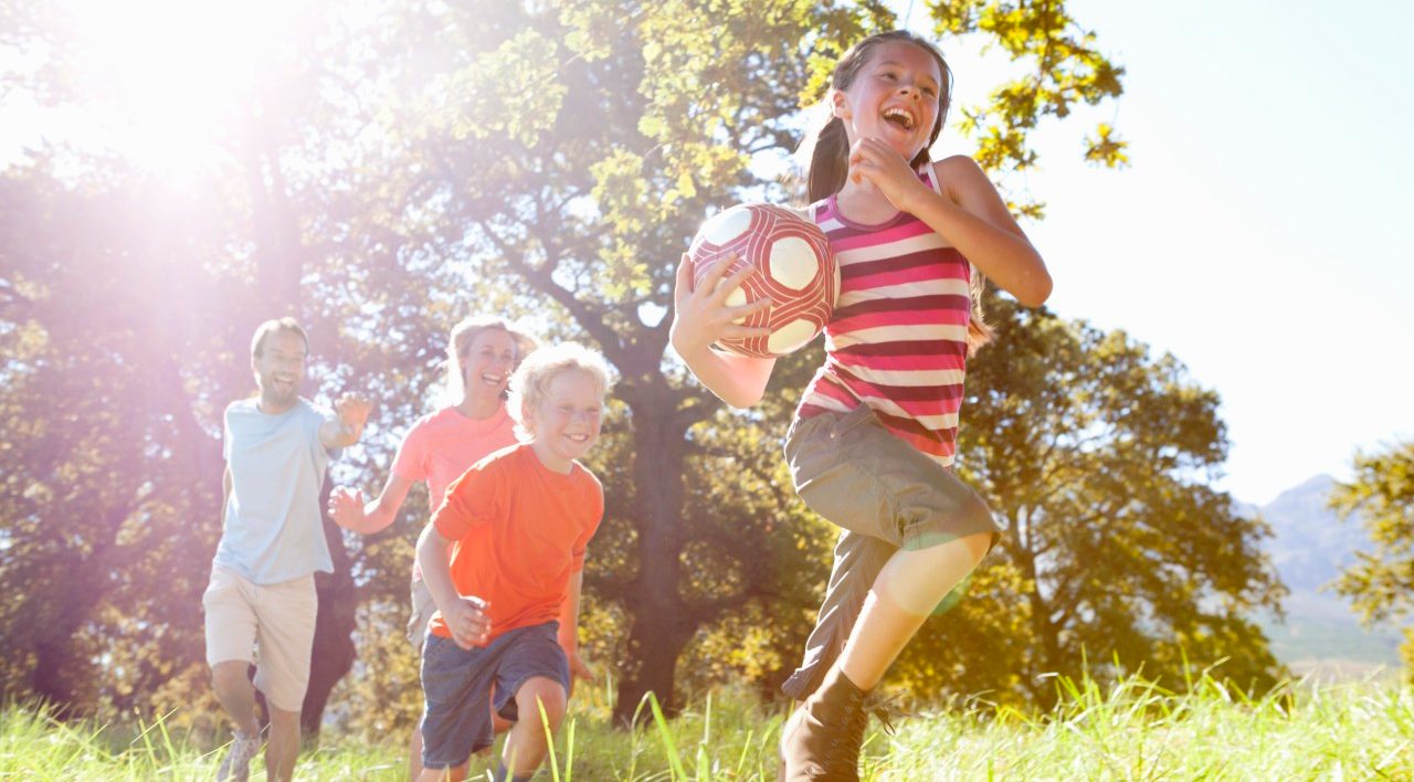 16 Sep 2014 --- Grandparents and grandchildren running with ball in rural field --- Image by © Ian Lishman/Juice Images/Corbis